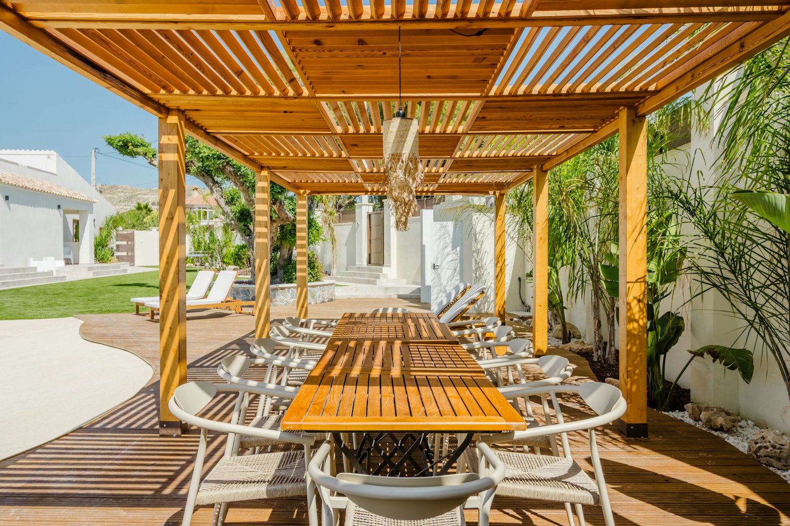 Sun-drenched villa terrace with olive trees and a view of the Mediterranean